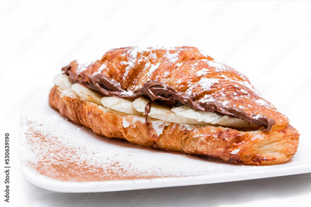 Croissant with chocolate butter and banana isolated on a white background. Croissant with chocolate butter and banana isolated on a white background.