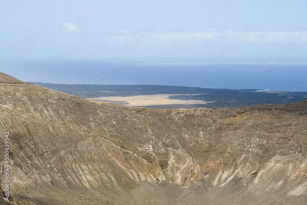 Volcanoes, black lava and islets of Lanzarote seen from Caldera Blanca