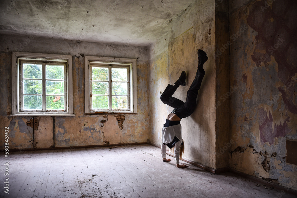 Choreographer girl doing an exercise in an old room of an abandoned house
