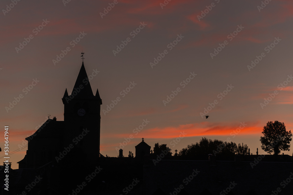 Silhouette of church of St Mathieu in Laguiole at sunset.