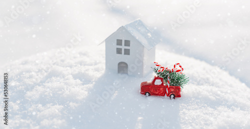 christmas decorative car with a Christmas tree in the snow next house