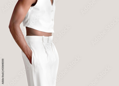 Detail of an African man dressed in formal clothes, white pants and vest on a white background