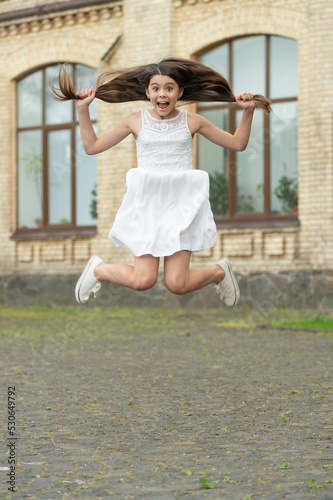 glad funny teen girl. jumping girl having fun. teenager girl jump outdoor