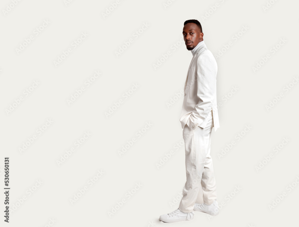 Horizontal portrait of an elegant african man dressed in white on a white background looking at the camera and copy space Horizontal portrait of an elegant african man dressed in white on a white background looking at the camera and copy space