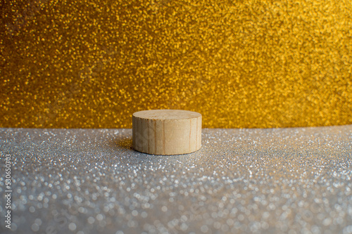 Wooden eco podium for product demonstration on a golden and silver shiny background