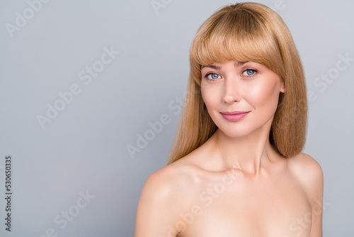 Photo of aesthetic mature lady stand empty space advertise silky soft beautician product isolated on grey color background