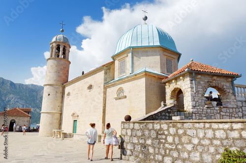 Perast, Montenegro - August 27, 2022: Island Our Lady of the Rock and Roman Catholic Church in Perast on Boka Kotor bay (Boka Kotorska) of Adriatic Sea in Balkan mountains, Montenegro, Europe. photo