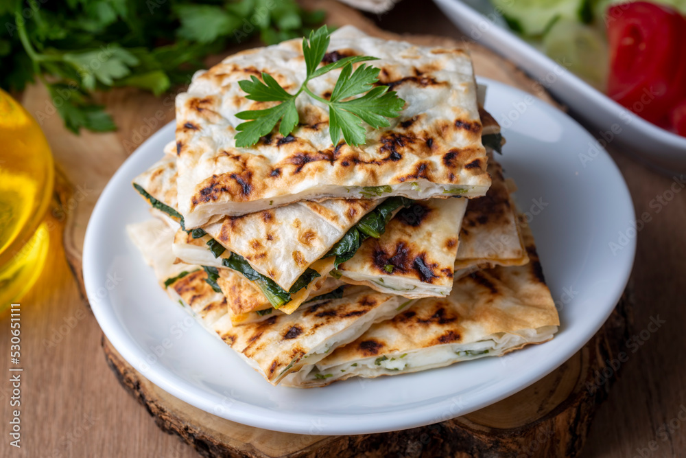 Traditional Turkish food, Turkish pancake gozleme with cheese and herb. The appetizer is Turkish pastry. There are varieties such as cheese, spinach, potato