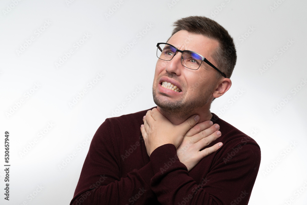 Fototapeta premium Handsome man wearing glasses over isolated background touching painful neck, sore throat from flu, cold and infection