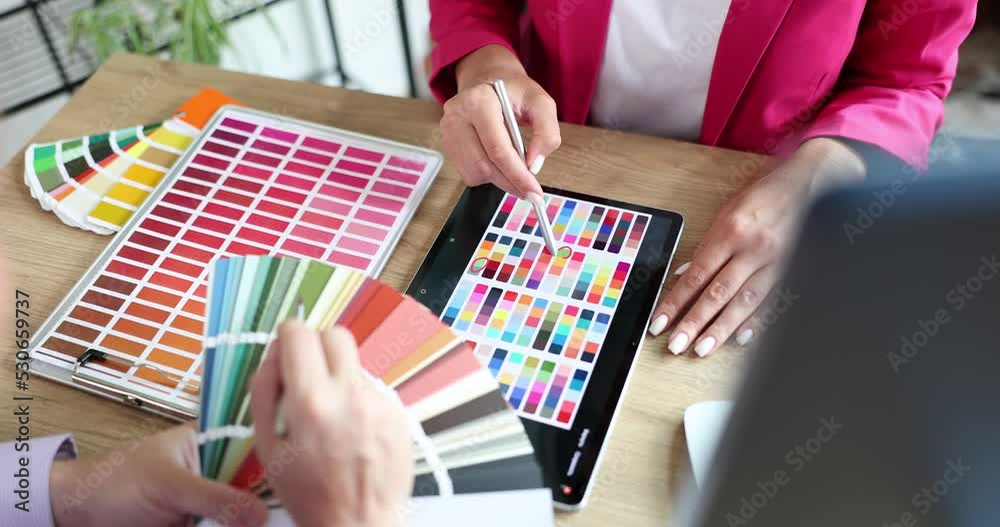 Closeup of fellow interior designers working with color palette and blueprint