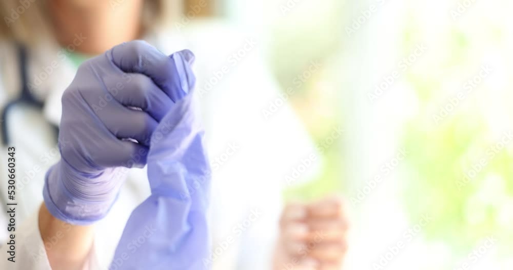 Doctor takes off medical gloves in lab coat
