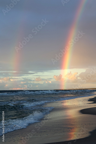 Kolorowa tęcza w czasie deszczu nad horyzontem morza.  © DarSzach