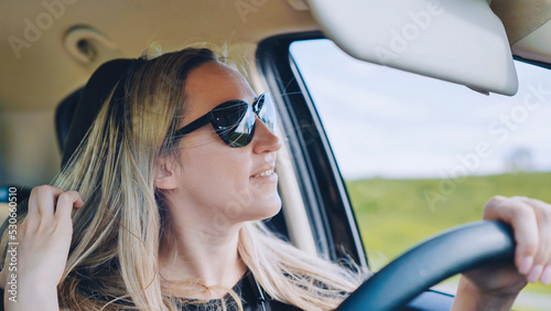 A young woman in a good mood behind the wheel of a car. © Довидович Михаил