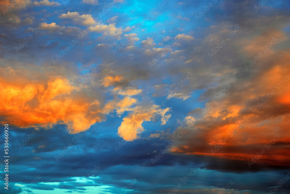Fantastically beautiful clouds at sunrise in orange-blue tones, background for design