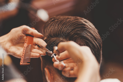 Barbershop concept, vintage color. Portrait happy client man in haircut salon, master does hair styling