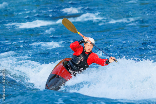 Extreme sport rapid passage, kayaker man in kayak boat whitewater rafting, blue water © Parilov