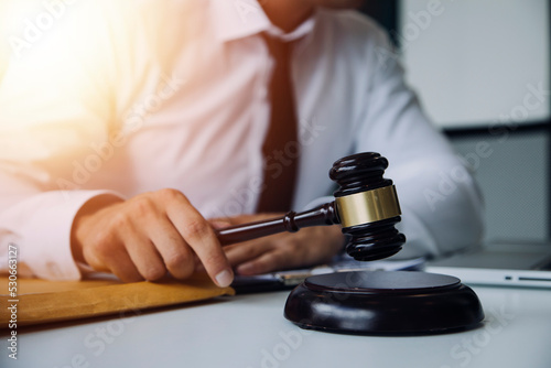 Male lawyer working with contract papers and wooden gavel on tabel in courtroom. justice and law ,attorney, court judge, concept. © ARMMY PICCA