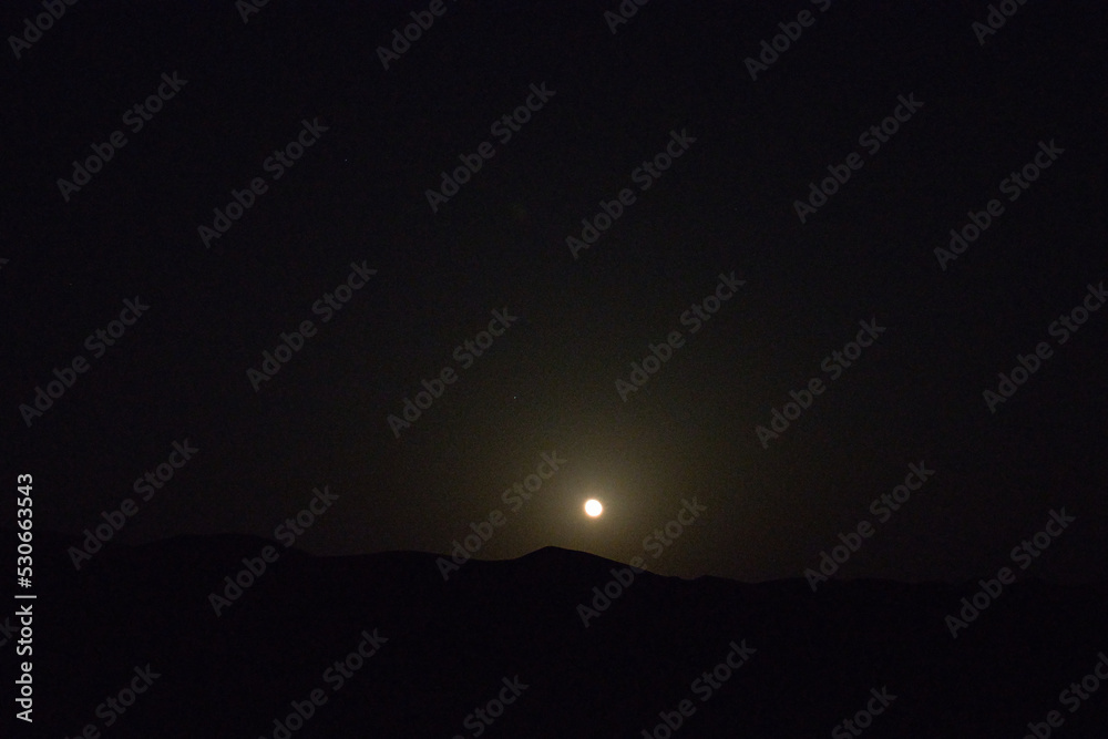 Naklejka premium rising moon over the desert