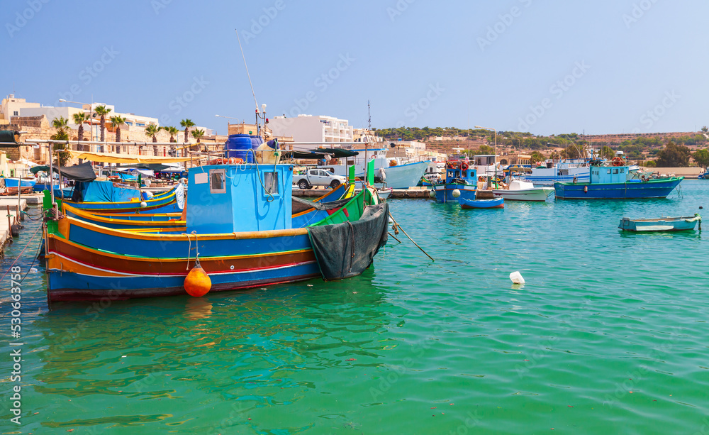 Colorful Maltese fishing boats are moored in Marsaxlokk