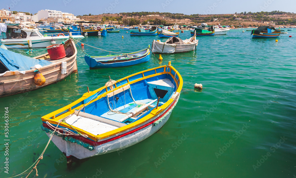 Small colorful Maltese fishing boats moored in Marsaxlokk