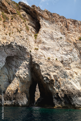 Vertical coastal landscape with narrow dark cave