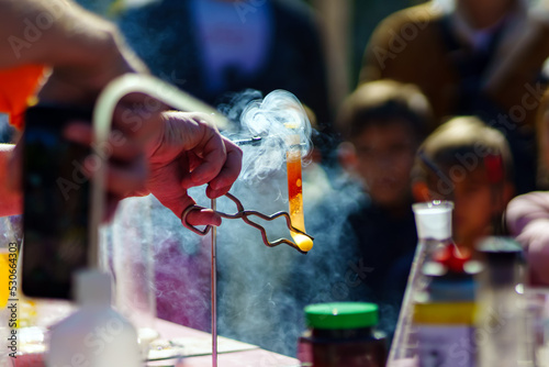 A person bends a hot test tube with special tongs