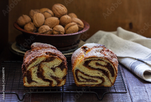 Traditional Easter bread with chocolate and nut filling on a wooden background.