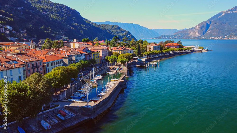 Aerial view of Lake Como. city ​​center. A local ferry arrives in the city. Bell tower. Tourism and romance. Mountains around the lake. Red roofs. Green Planet. Sailing yacht. Italy, Bellano, 10.2022