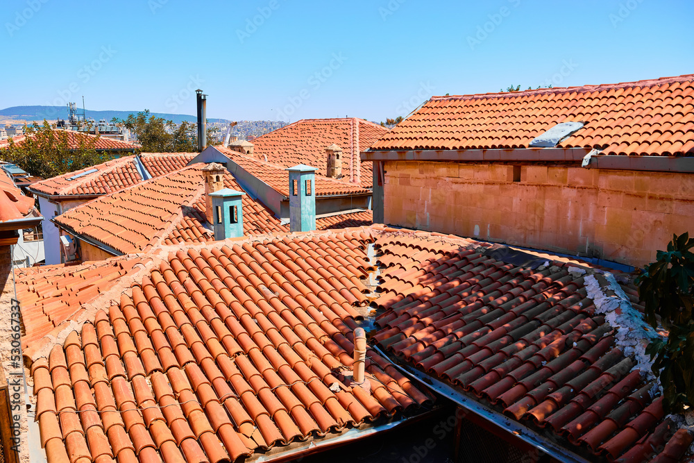 Brown tiled roofs of middle eastern town and bright blue sky