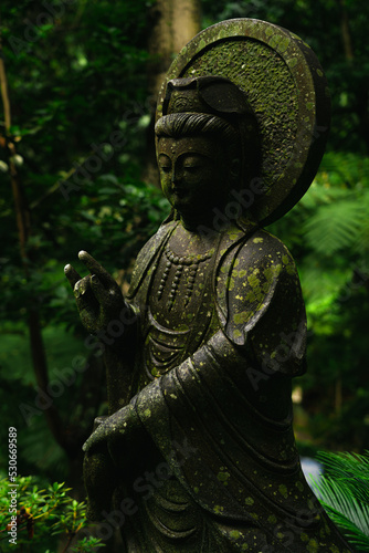 Old statue of oriental god in botanical garden