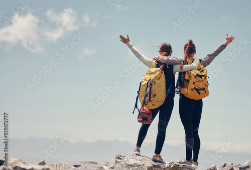 Fotografiet Hiking friends celebrate climbing mountain peak together on rocky summit as healthy, fitness and trekking women