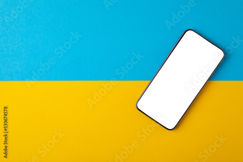 empty screen mobile phone on the background of the flag of ukraine