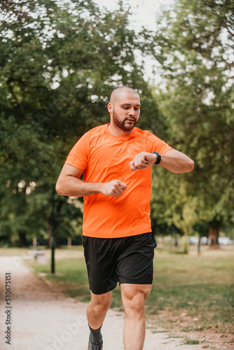 Athlete using a smartwatch while running in nature Healthy lifestyle