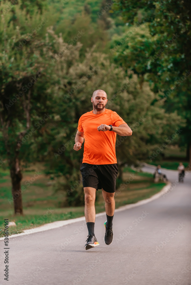 Athlete using a smartwatch while running in nature Healthy lifestyle