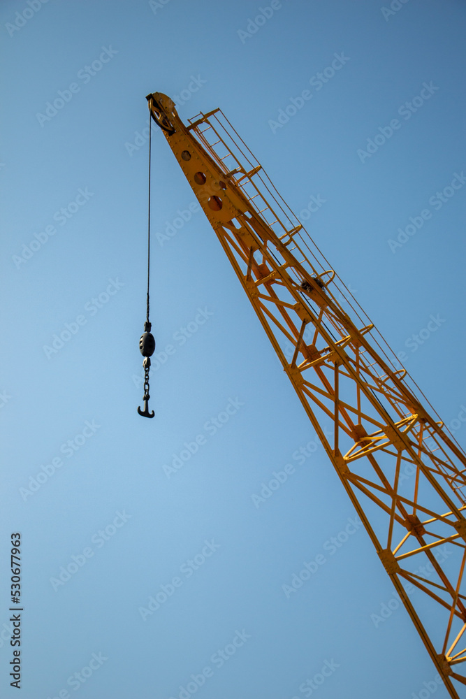 Crawler crane against blue sky. Real estate industry.