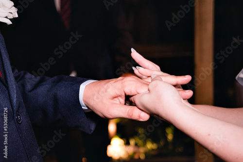bride's hands holding groom's hand at wedding