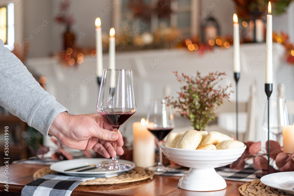 Man setting a wineglass on a holiday dinner table Man setting a wineglass on a holiday dinner table