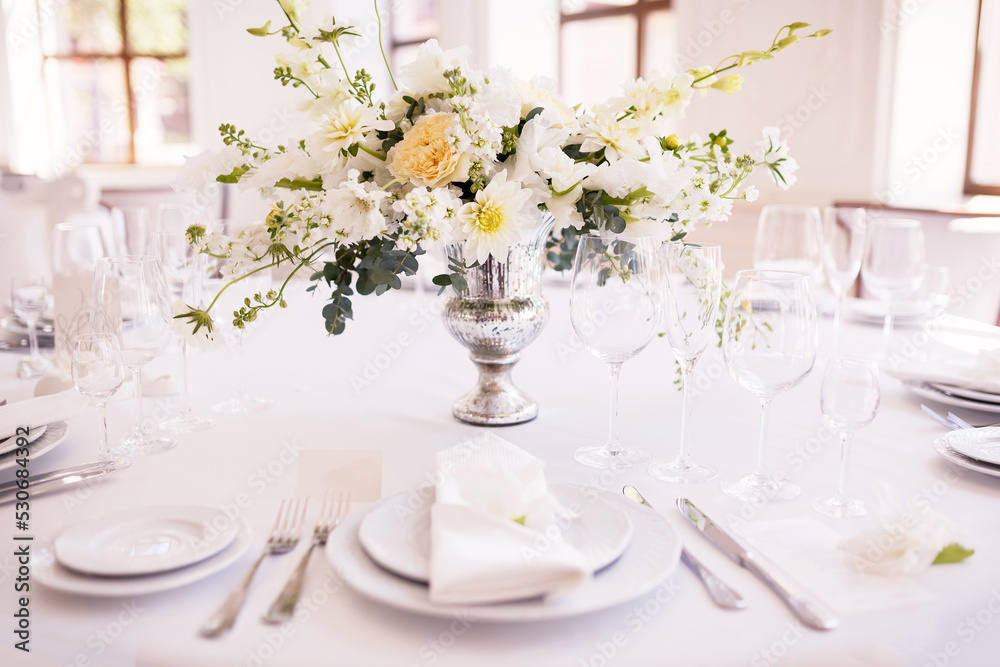 A table decorated with white flowers for seating guests at a wedding banquet. Selective focus.