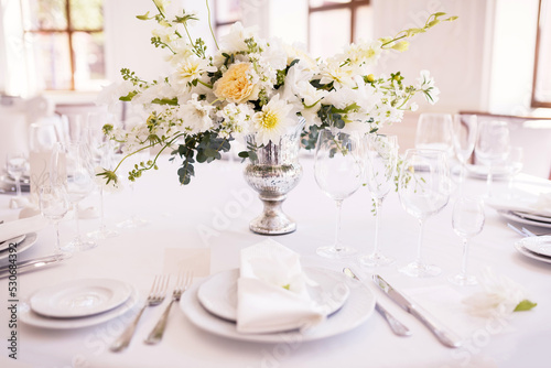 A table decorated with white flowers for seating guests at a wedding banquet. Selective focus. © ClareM