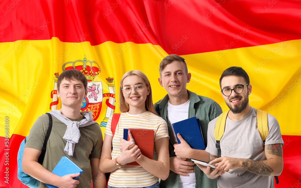 Obraz premium Group of students against flag of Spain. Concept of studying Spanish