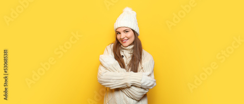 Beautiful young woman in knitted clothes on yellow background © Pixel-Shot