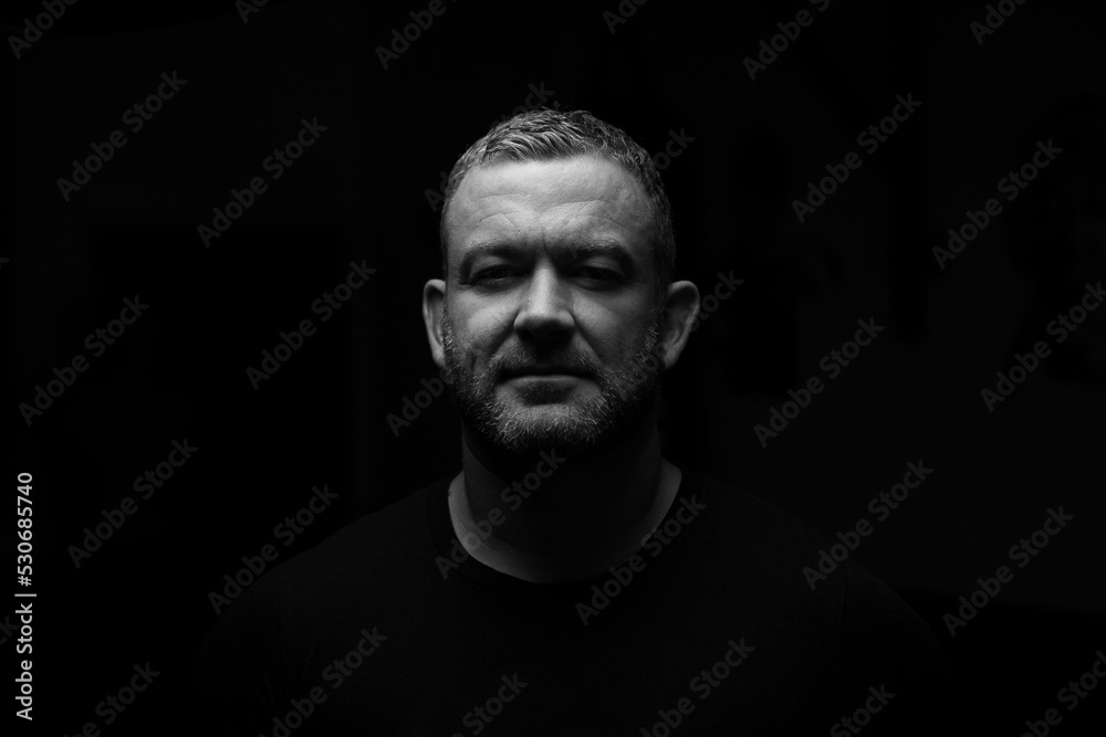 Fototapeta premium Adults male in darkness and looking into camera.
