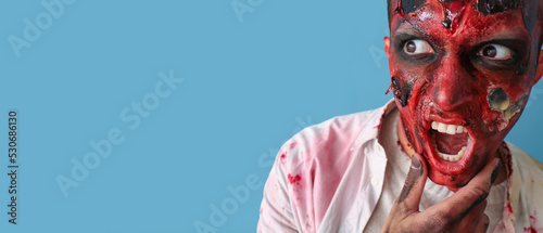Scary zombie man on blue ba...