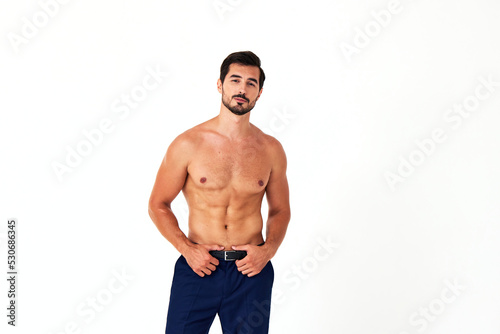 Man with bare torso and prue cubes in business pants shows full-length nude body, women's day March 8 on white isolated background copy space  photo