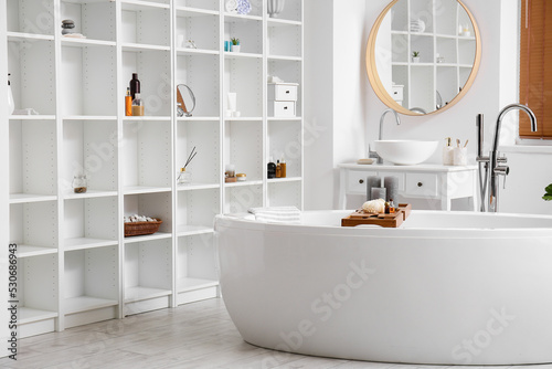 Modern shelving unit with different accessories in bathroom