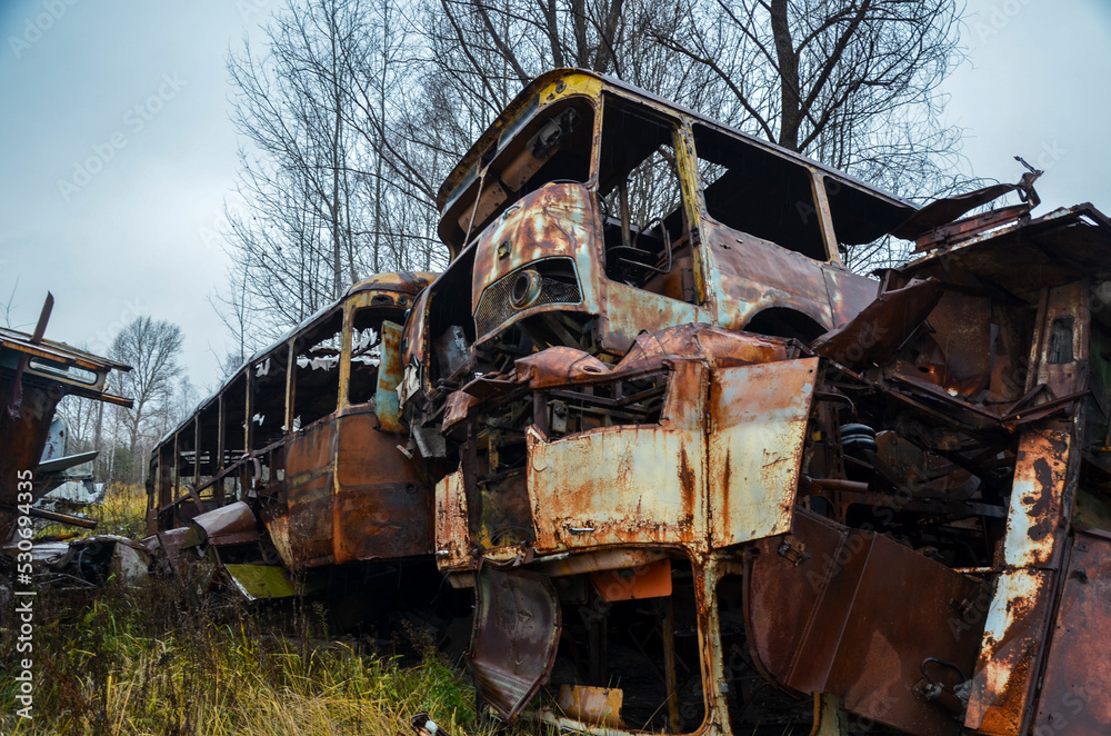 Broken destroyed rusty buses in recycling scrap yard
