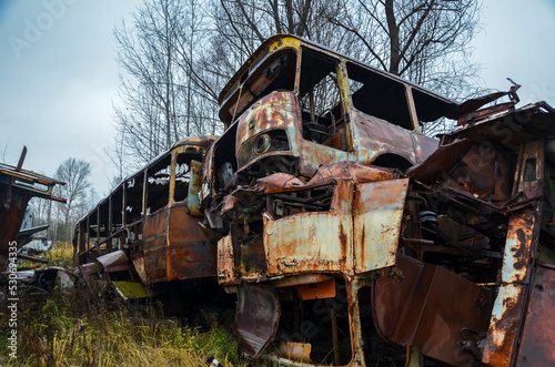 Broken destroyed rusty buses in recycling scrap yard 
