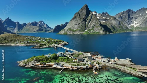 Aerial view overlooking the Sakrisoya fishing town, summer in sunny Lofoten, Norway - pull back, drone shot photo