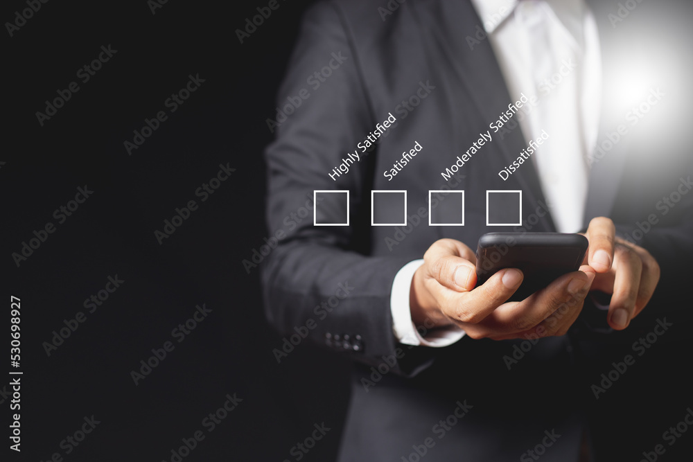 Concept customer satisfaction surveys. Choose satisfaction in the gap. Businessman using smartphone checklist mark ranking of satisfaction surveys. Feedback, rating, survey, positive, ranking. Concept customer satisfaction surveys. Choose satisfaction in the gap. Businessman using smartphone checklist mark ranking of satisfaction surveys. Feedback, rating, survey, positive, ranking.