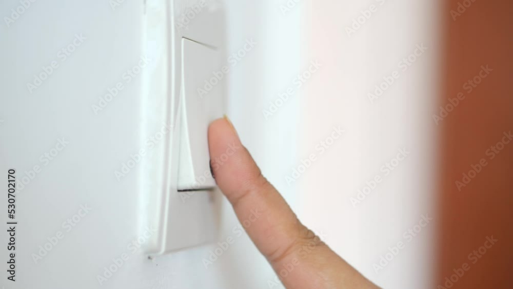 A finger turning on lighting switch .